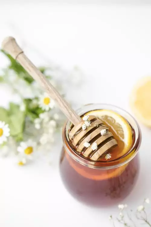 A beautiful Image of Honey in a bottle with a Spoon