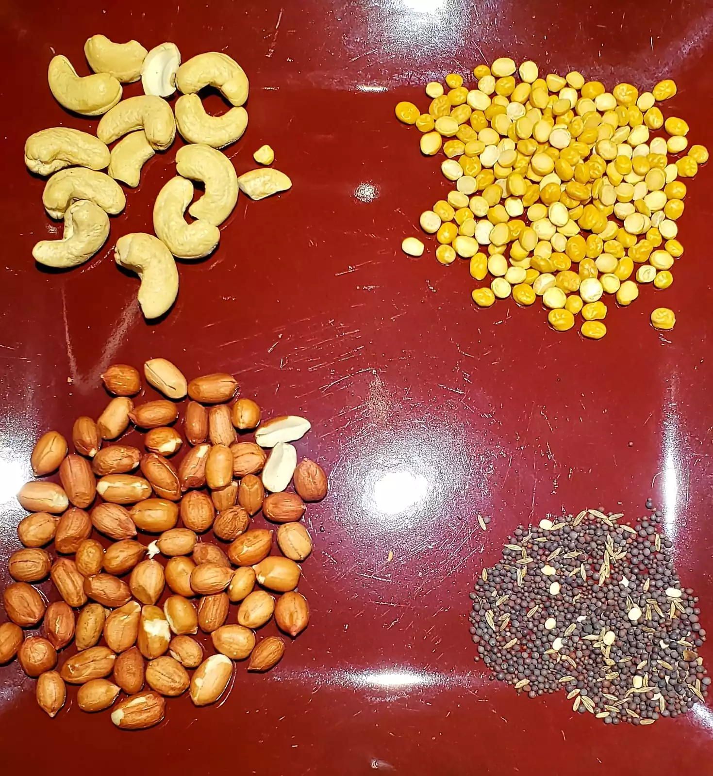 Pea nuts, Cashew, Split chick peas, Mustard seeds on a plate for tampering to make tasty raw mango rice