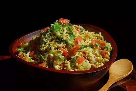 Tasty & Healthy Sprout Puffed rice in a wooden bowl with cilantro and tomato topping
