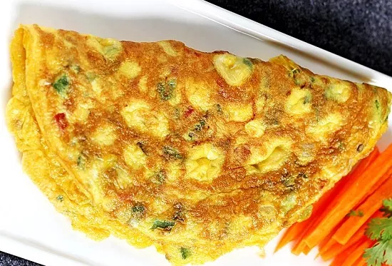 An Omlette served in a plate with some salad