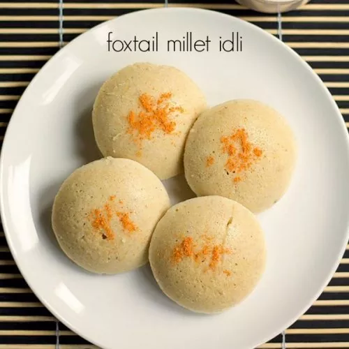 Foxtail millet idly served in a white plate with grated carrot on the top